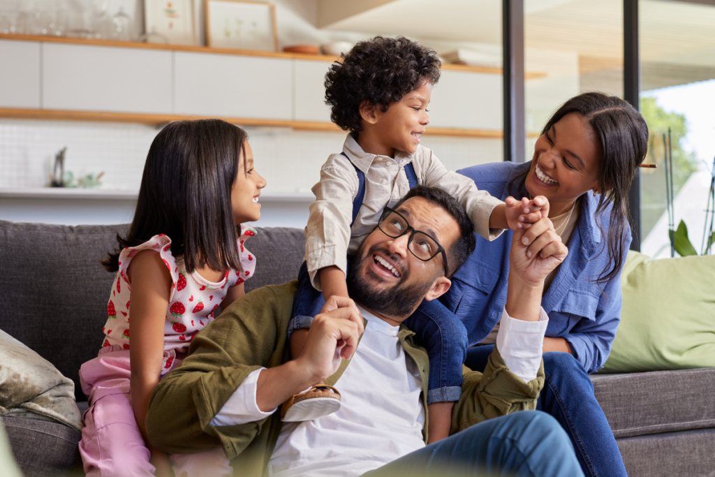Family on couch at new home in Jordan Ranch master-planned community Fulshear, TX