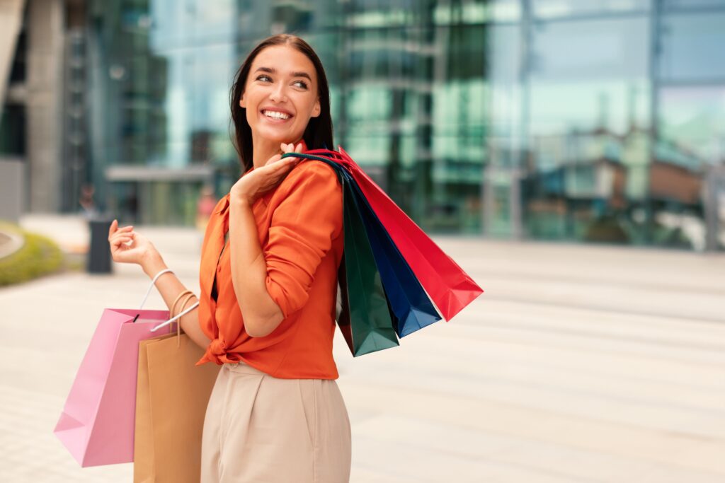 Woman holding shopping bags and smiling at Heritage Grove
